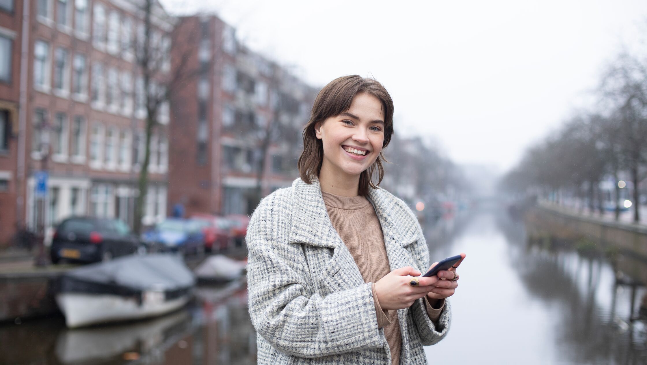 Jonge vrouw met telefoon die glimlacht